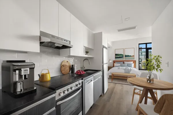 a kitchen with stainless steel appliances granite countertop a sink stove and white cabinets