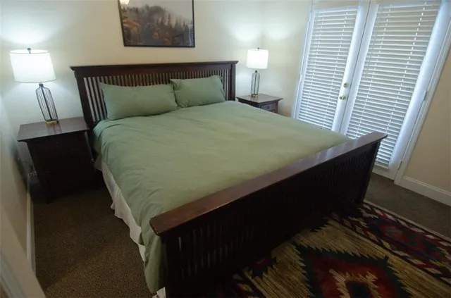 a bed sitting in a bedroom next to a lamp