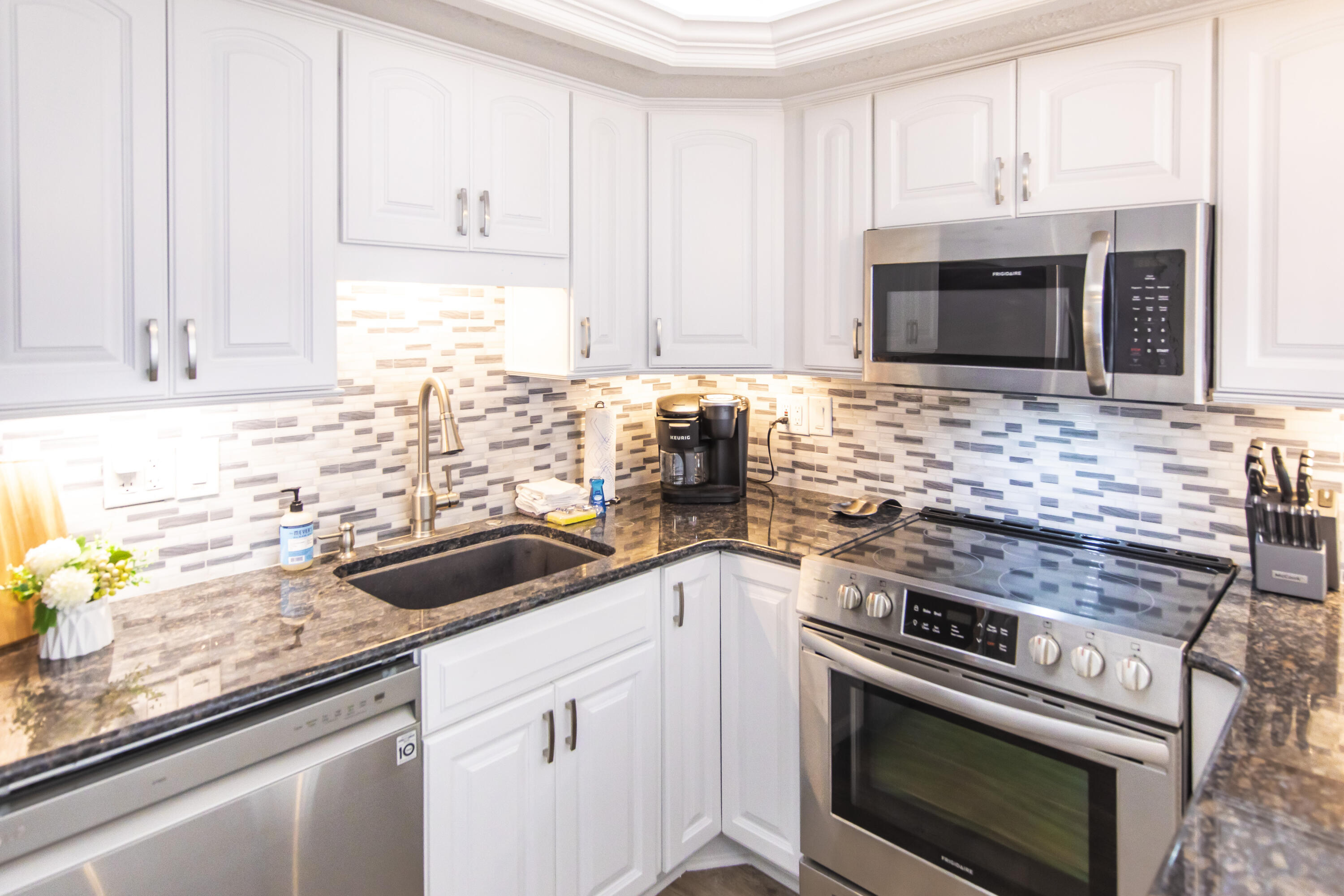 23223 Front Beach Road, Unit A122 Panama City Beach, FL 32413 - Photo 10 of 45 a kitchen with granite countertop a sink stainless steel appliances and cabinets