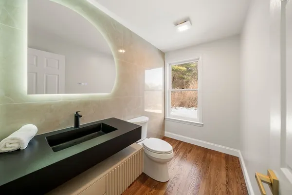 a bathroom with a sink a toilet and a window