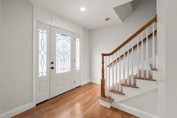 a view of an entryway with wooden floor and door