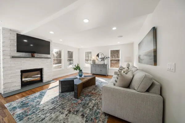 a living room with furniture a flat screen tv and a fireplace