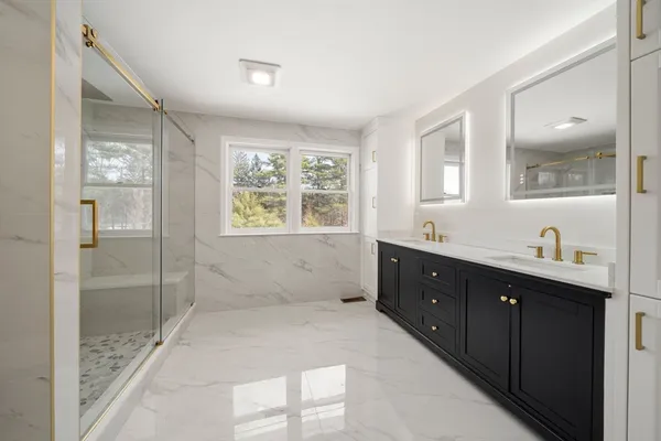a spacious bathroom with a double vanity sink mirror and shower