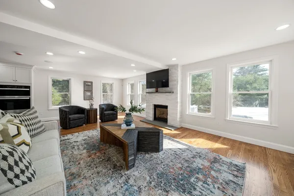 a living room with fireplace furniture and a rug