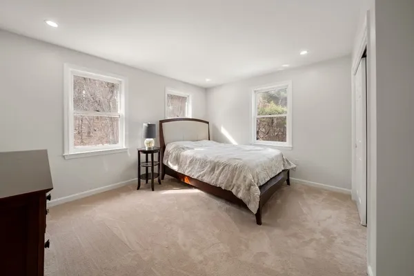 a bedroom with a bed lamp and a window