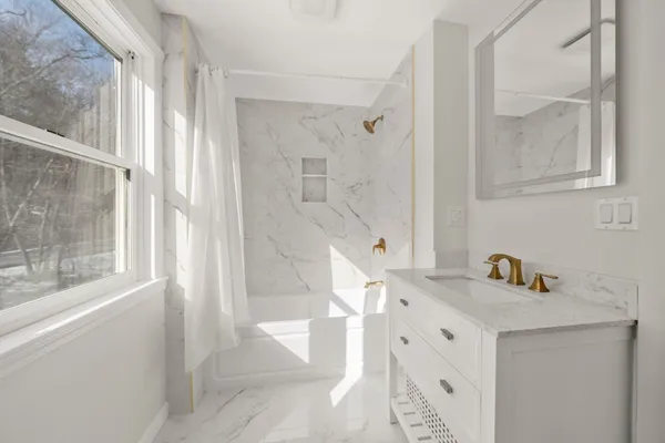 a bathroom with a sink a mirror and a shower