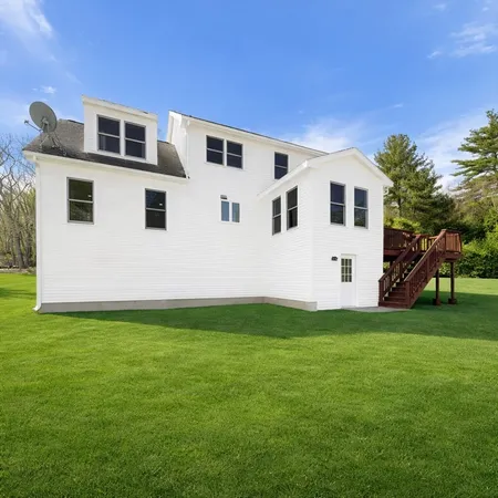 a white house that has a big yard in front of it