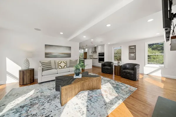 a living room with furniture wooden floor and a flat screen tv