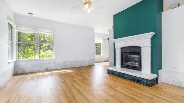 a living room with a fireplace with wooden floor