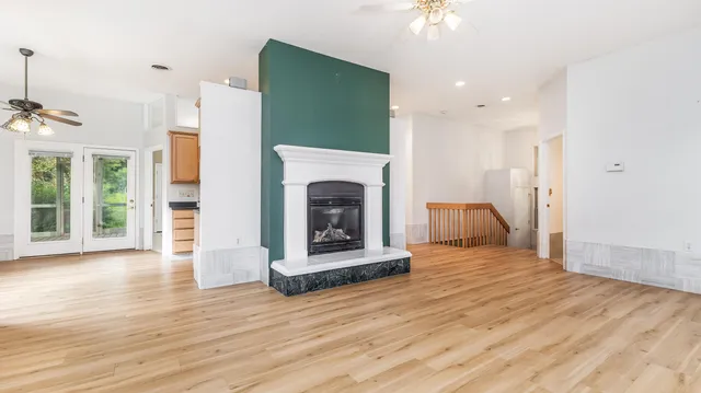 a view of an empty room with a fireplace and a window