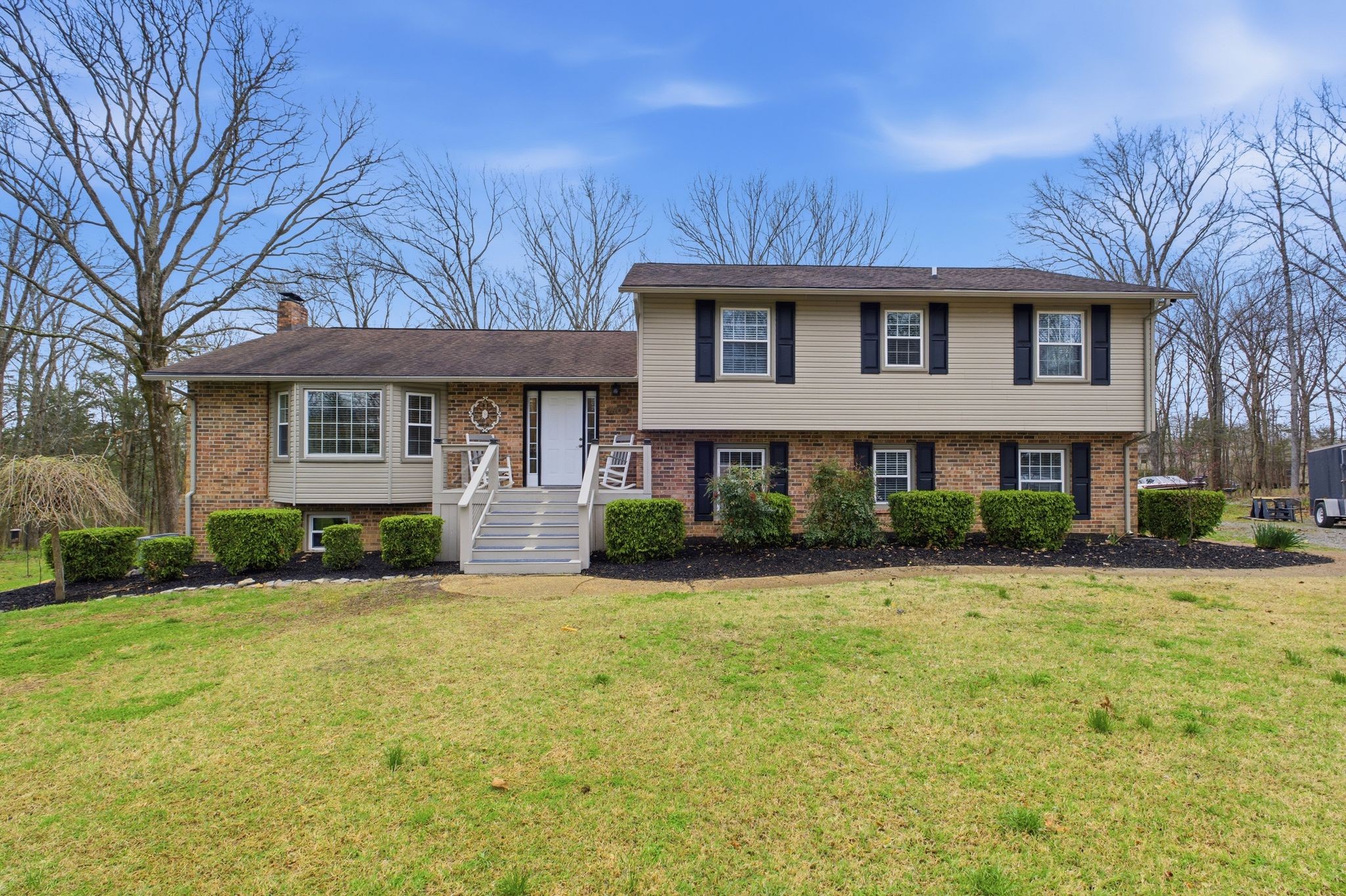 a front view of a house with yard and green space