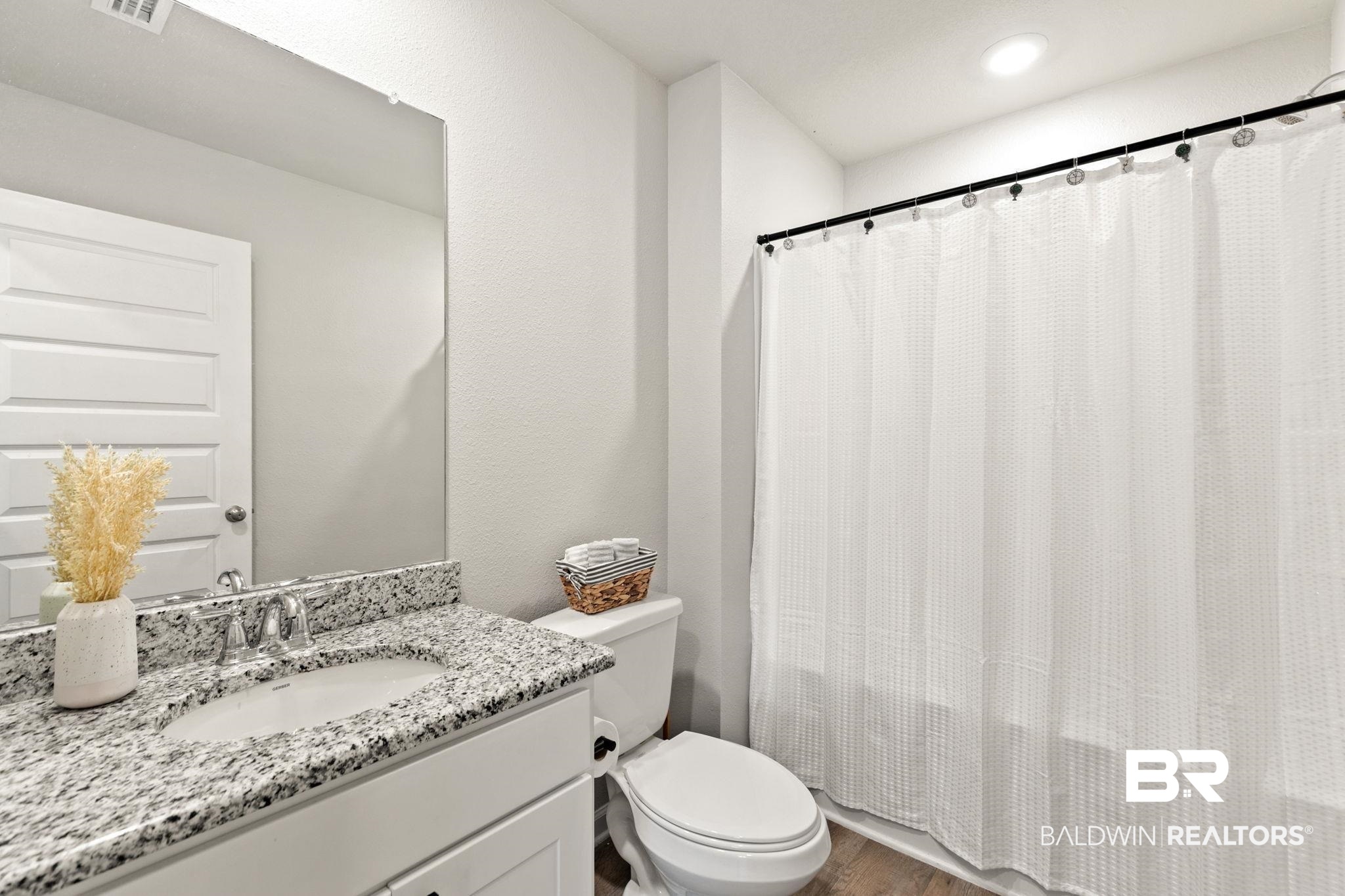 32234 Calder Court Daphne, AL 36527 - Photo 16 of 32 Bathroom with vanity, dark wood-style flooring, and a textured wall