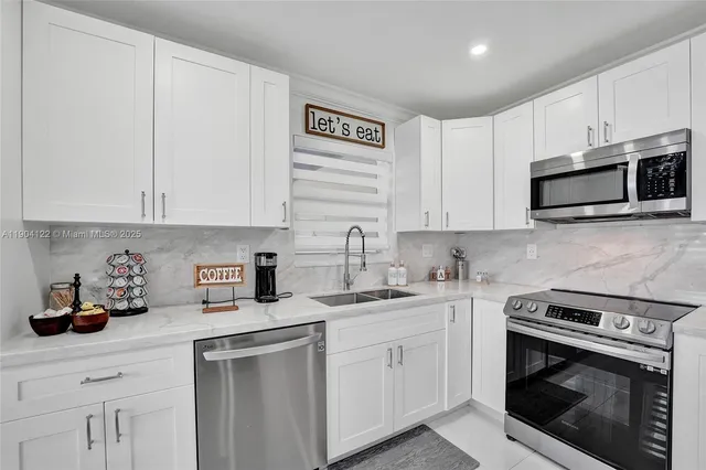 a kitchen with cabinets stainless steel appliances and sink
