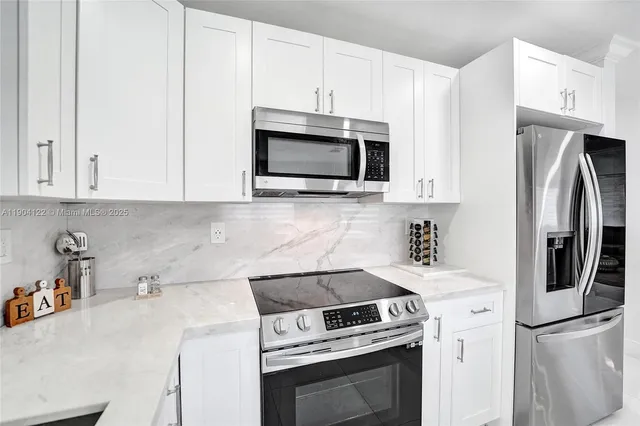 a kitchen with stainless steel appliances white cabinets and a sink