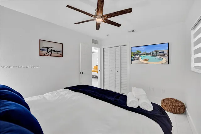 a bedroom with a bed and ceiling fan
