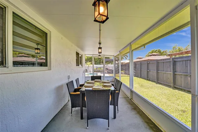 a view of a dining room with furniture a chandelier and wooden floor
