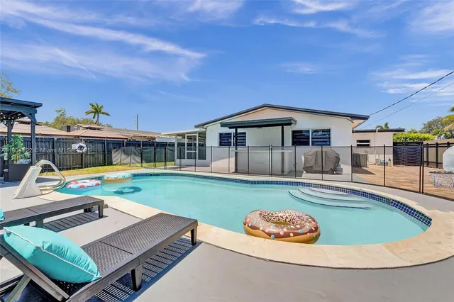 a view of a swimming pool with furniture