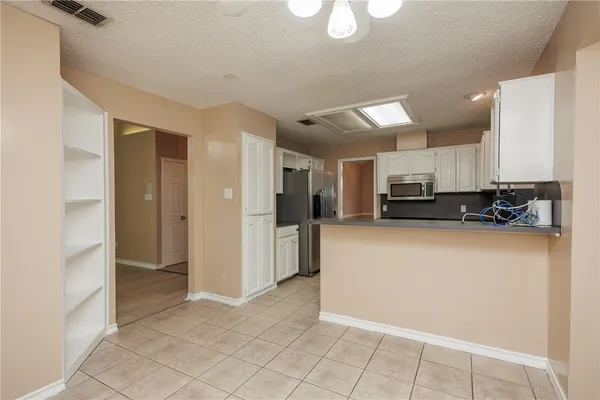 a view of a kitchen with stainless steel appliances a refrigerator and a stove