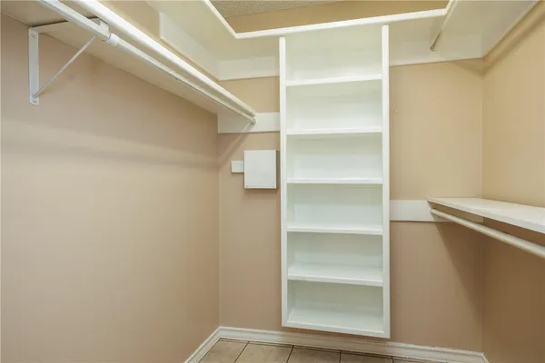 a view of walk in closet with empty racks