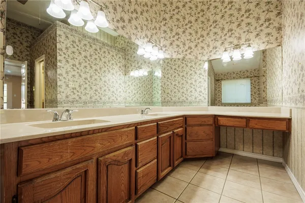 a spacious bathroom with a sink a mirror and a bathtub