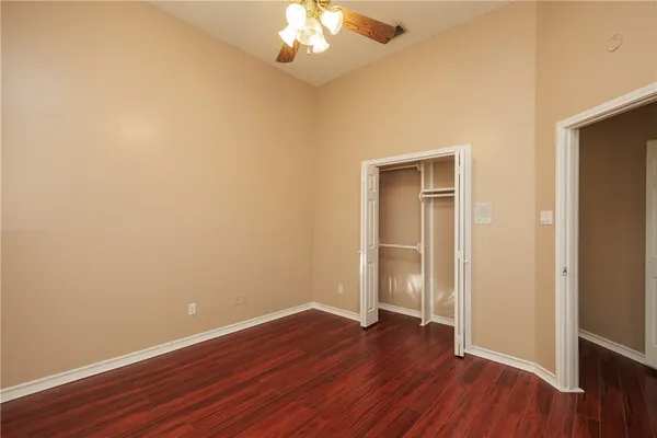 a view of empty room with wooden floor and window