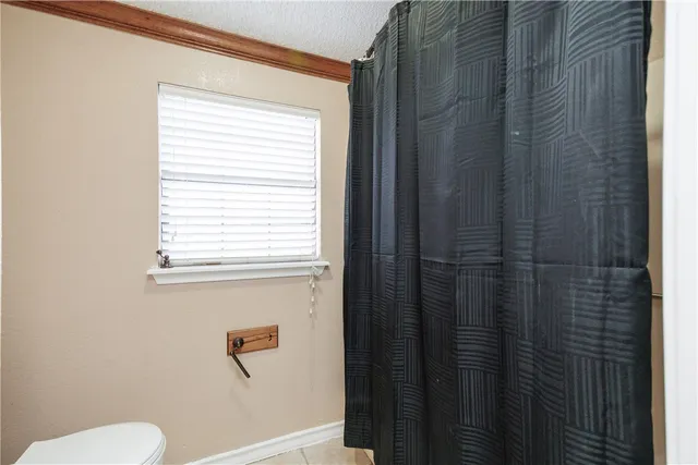 an empty room with wooden floor chandelier fan and windows