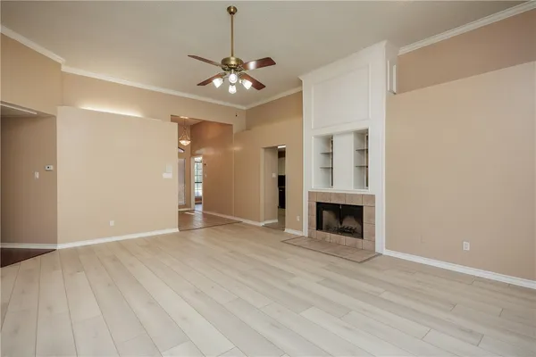 a view of an empty room with a fireplace and a window