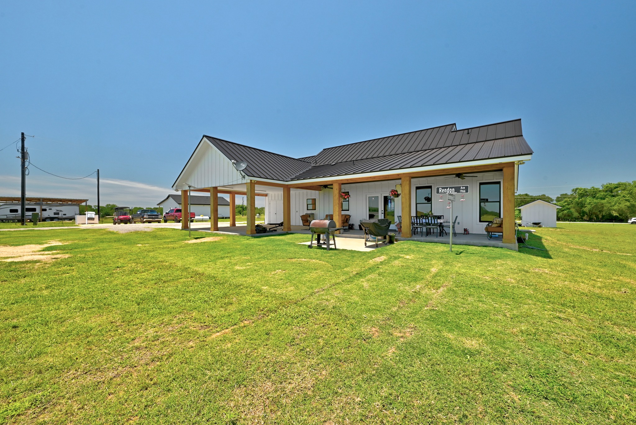 2889 Old McMahan Road Lockhart, TX 78644 - Photo 27 of 33 A sprawling green lawn complements this white-sided home featuring a covered patio, ideal for outdoor gatherings.
