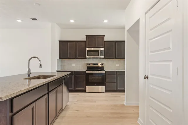a view of an empty room with wooden floor and a cabinet