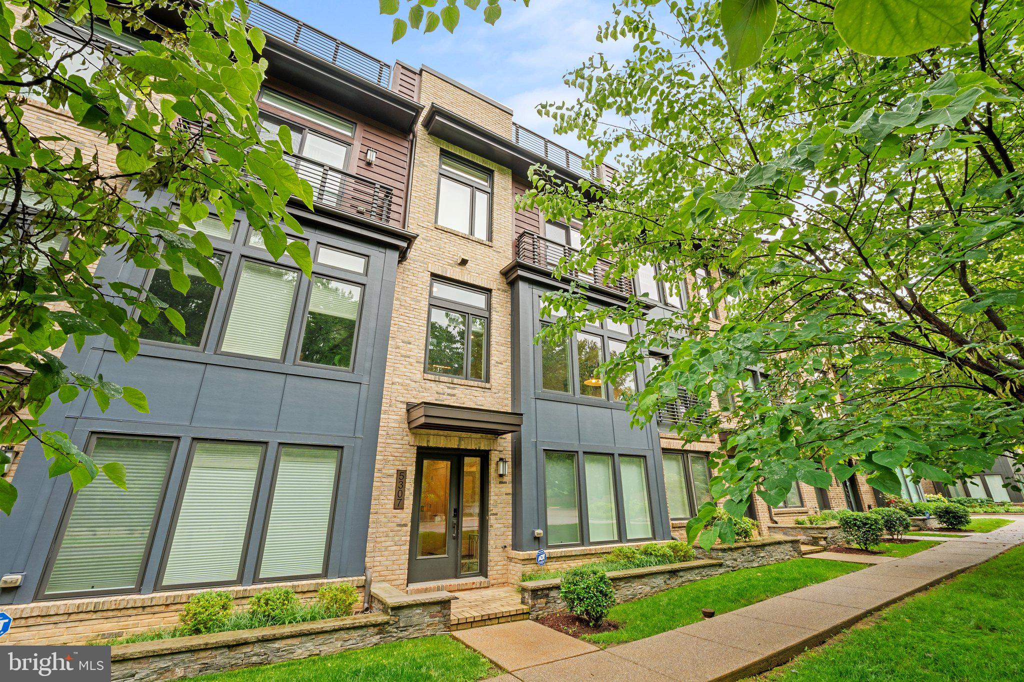 a view of a white house with a big yard and large tree
