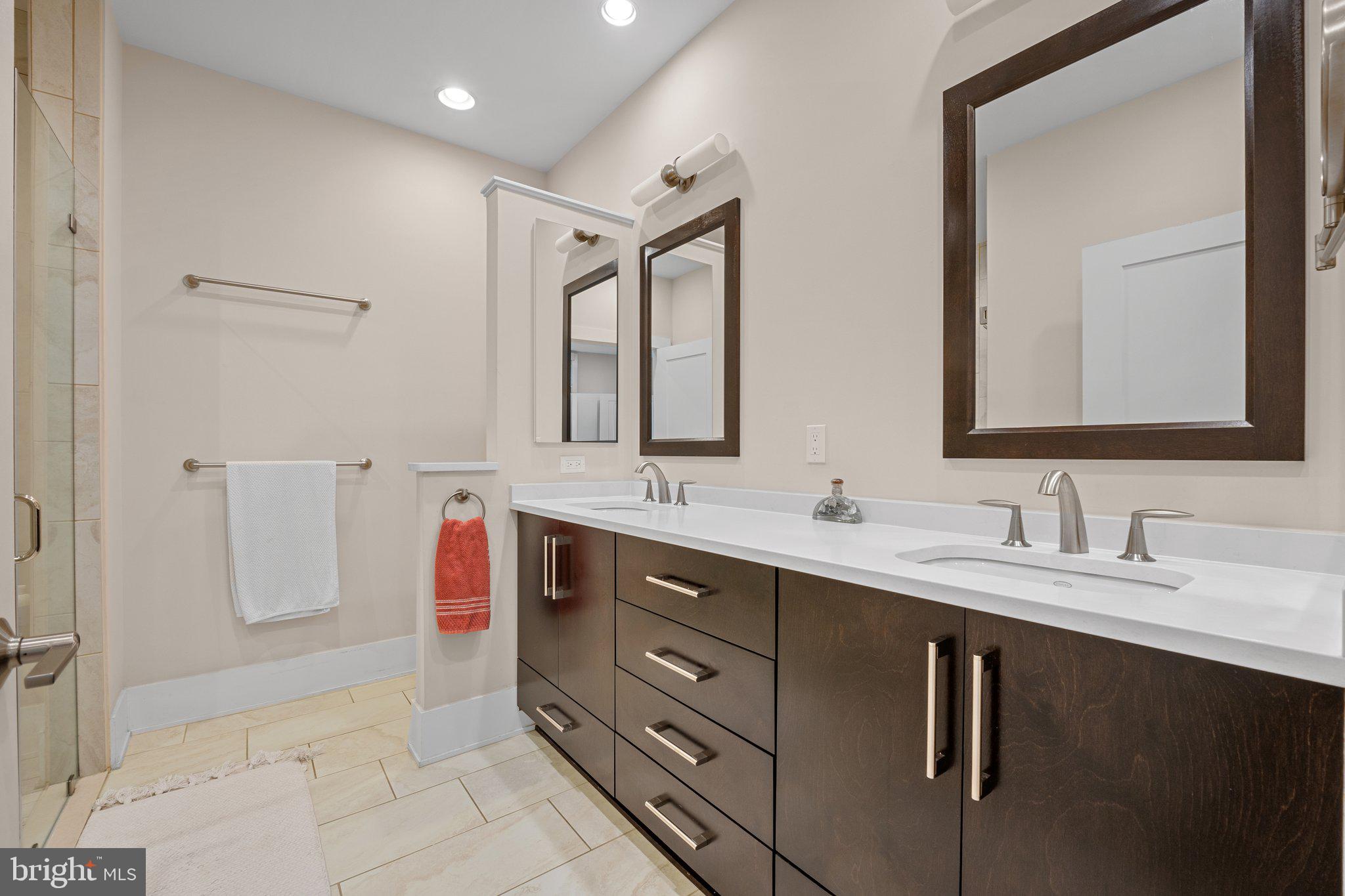 5307 Merriam Street Bethesda, MD 20814 - Photo 20 of 32 a spacious bathroom with a double vanity sink a mirror and a shower