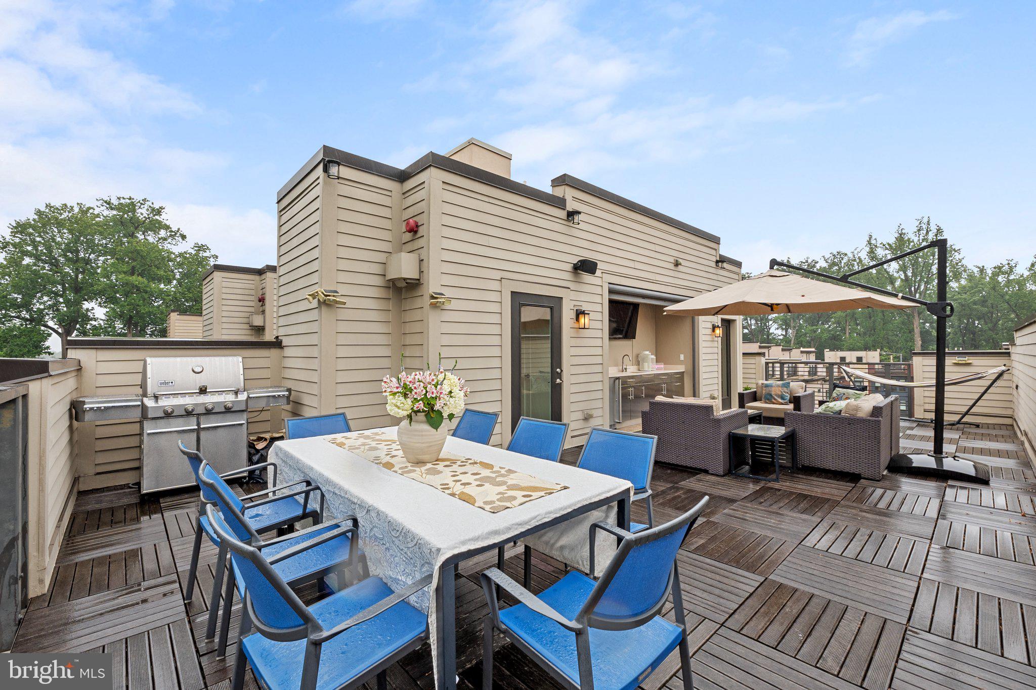 5307 Merriam Street Bethesda, MD 20814 - Photo 29 of 32 a roof deck with a dining table and chairs with a barbeque