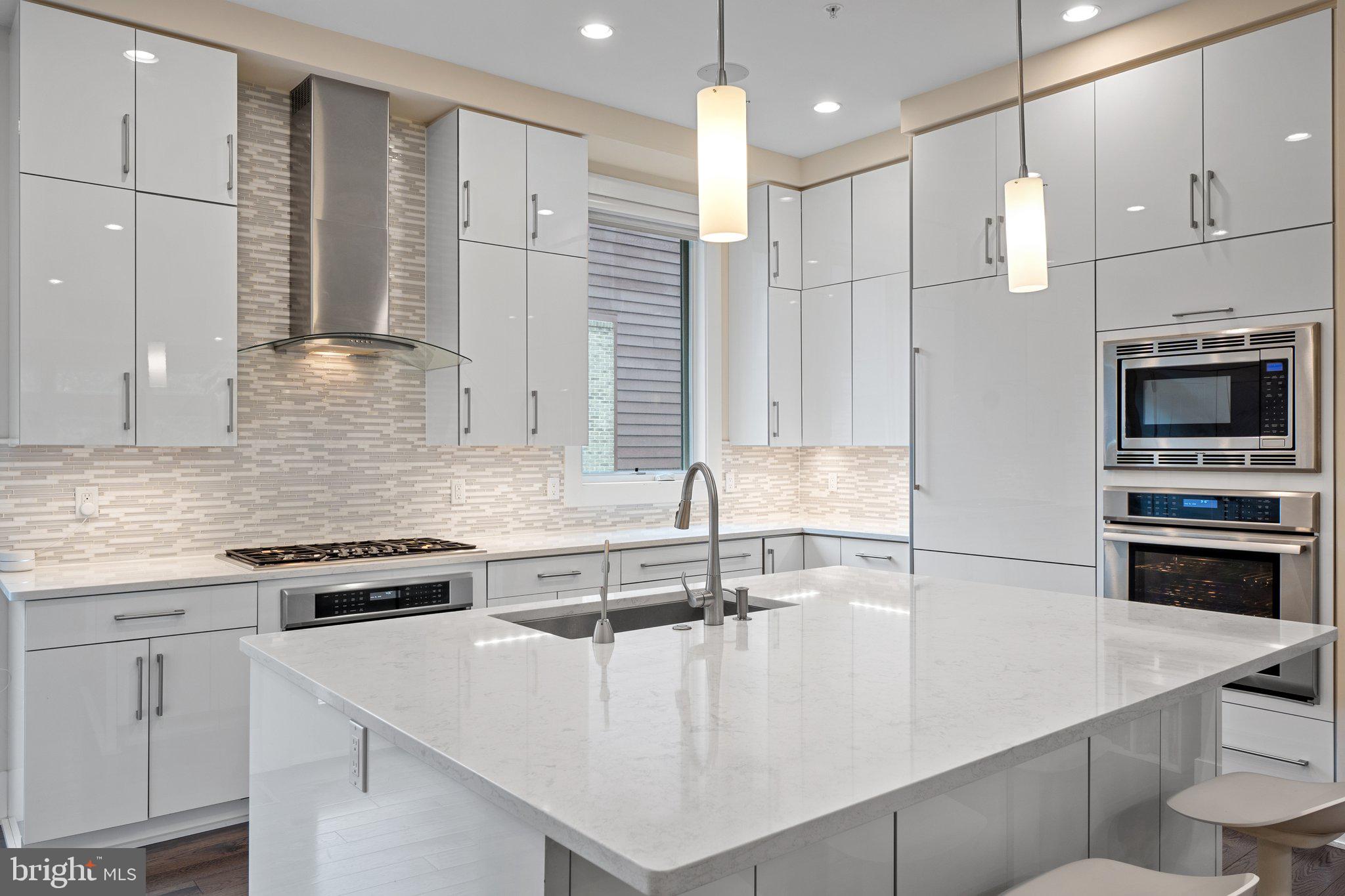 5307 Merriam Street Bethesda, MD 20814 - Photo 4 of 32 a large kitchen with stainless steel appliances a large counter top a stove a sink and a refrigerator
