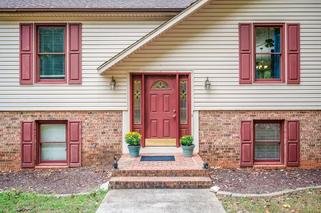 a front view of a house with a garden and plants
