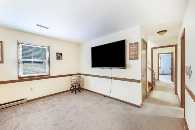 a view of an empty room with a window and a flat screen tv