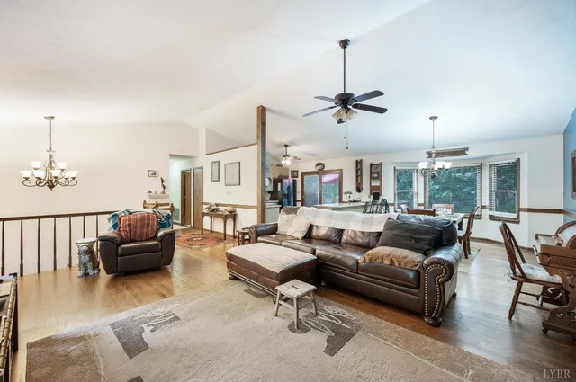 a living room with furniture ceiling fan and a wooden floor