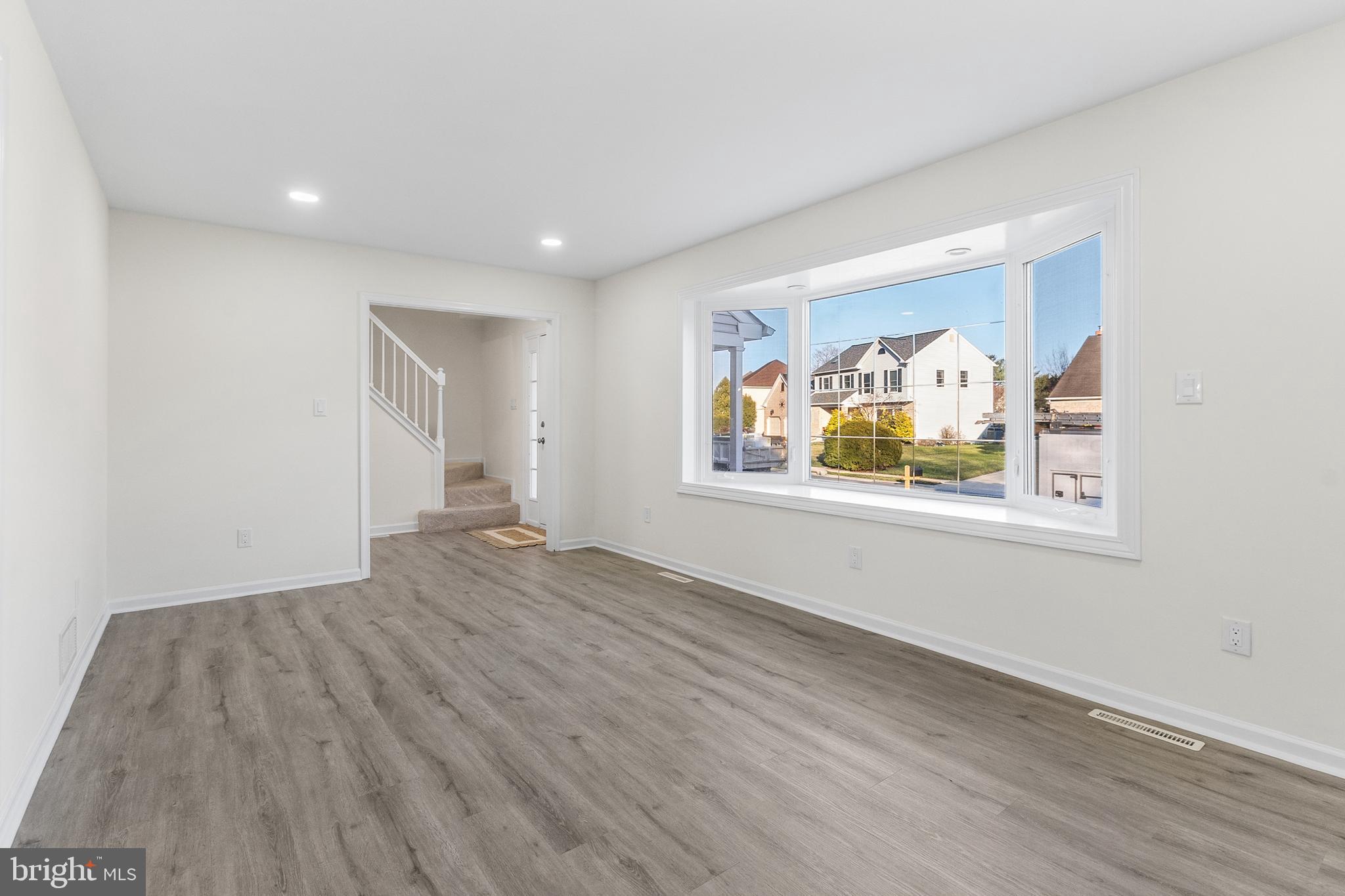 210 West Silver Fox Road Newark, DE 19702 - Photo 6 of 43 a view of an empty room with window and wooden floor