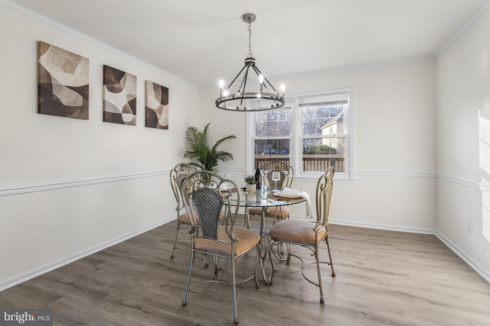 210 West Silver Fox Road Newark, DE 19702 - Photo 7 of 43 a dining room with wooden floor a chandelier a wooden table and chairs