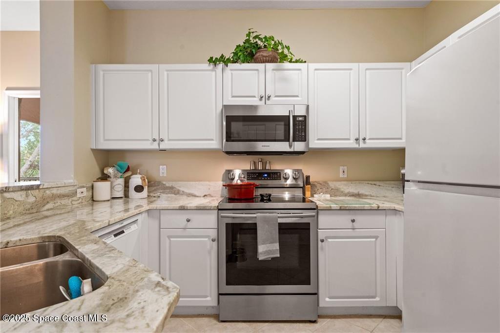 Undisclosed Address Vero Beach, FL 32967 - Photo 11 of 34 a kitchen with granite countertop a sink a stove and cabinets