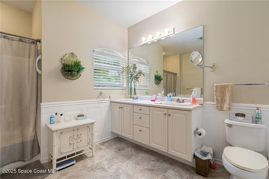 Undisclosed Address Vero Beach, FL 32967 - Photo 15 of 34 a bathroom with a double vanity sink mirror and toilet