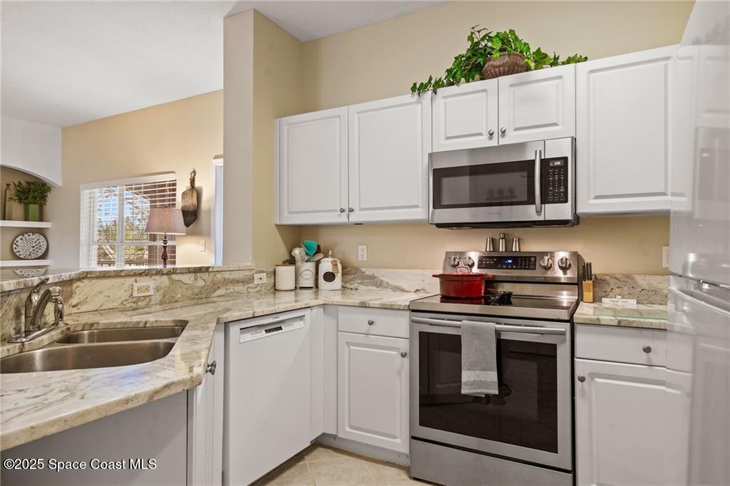 Undisclosed Address Vero Beach, FL 32967 - Photo 10 of 34 a kitchen with granite countertop white cabinets white stainless steel appliances and a sink