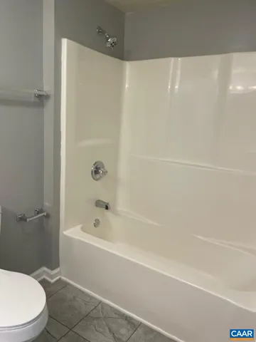 a white bath tub sitting next to a white toilet and a shower