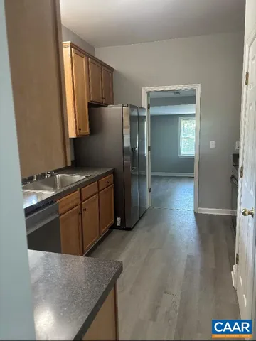 a kitchen with stainless steel appliances granite countertop a refrigerator a stove and a sink