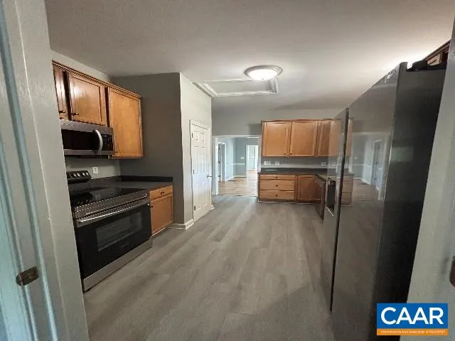 a kitchen with granite countertop a refrigerator and a stove top oven