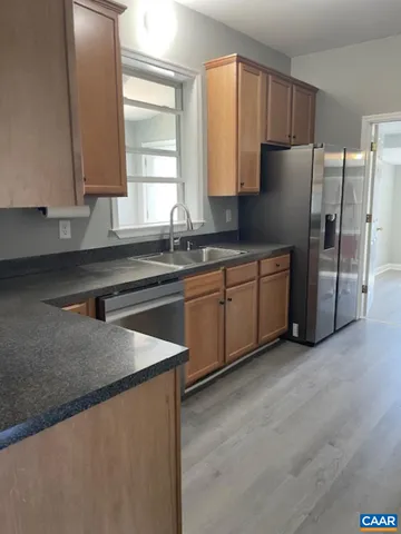 a kitchen with stainless steel appliances granite countertop a sink a refrigerator and a granite counter tops