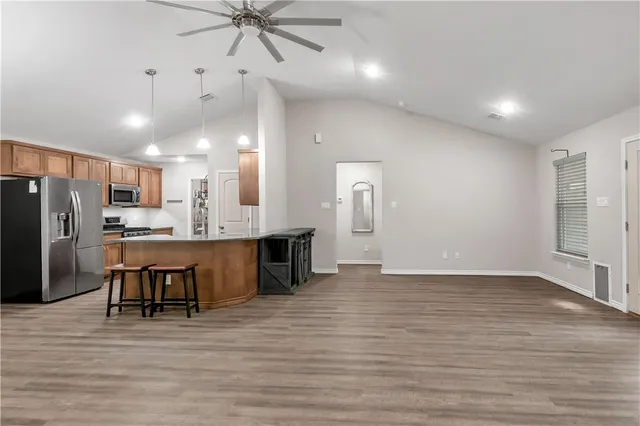 a view of kitchen with refrigerator microwave and cabinets