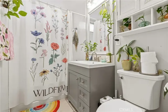 a bathroom with a sink a toilet and shower curtain