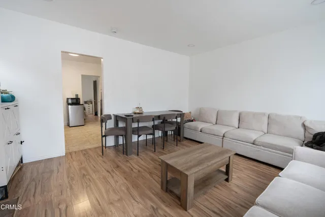 a living room with furniture and a dining table with kitchen view
