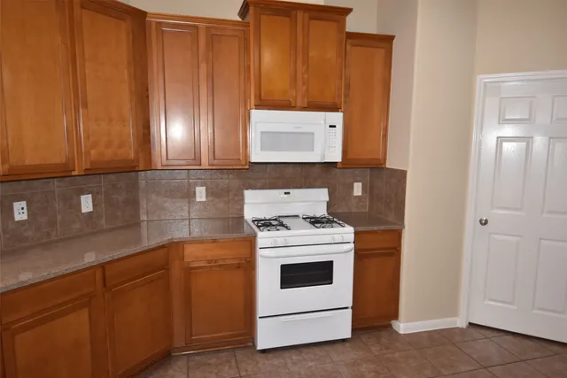 a kitchen with cabinets appliances and wooden floor