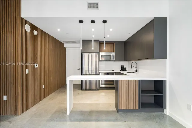 a view of kitchen with kitchen island a sink stainless steel appliances and cabinets